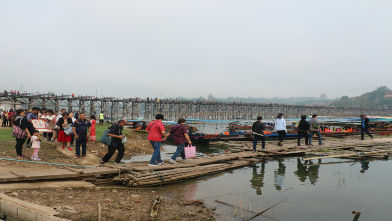 บรรยากาศส่งท้ายปีเก่าต้อนรับปีใหม่ กาญจนบุรีคึกคัก นักท่องเที่ยวแห่เที่ยวทำบุญตักบาตรถ่ายรูปบนสะพานไม้ฯ